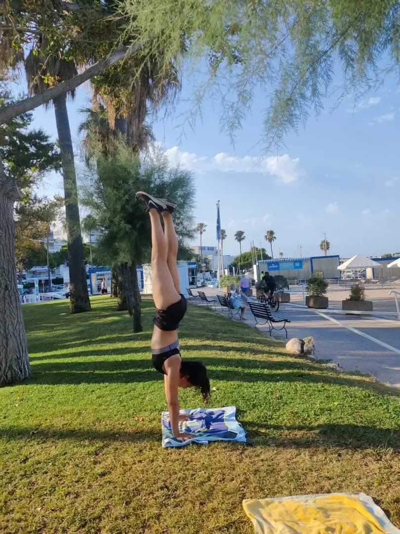 Équilibre sur les mains (Adho Mukha Vrksasana) dans un parc en bord de mer
