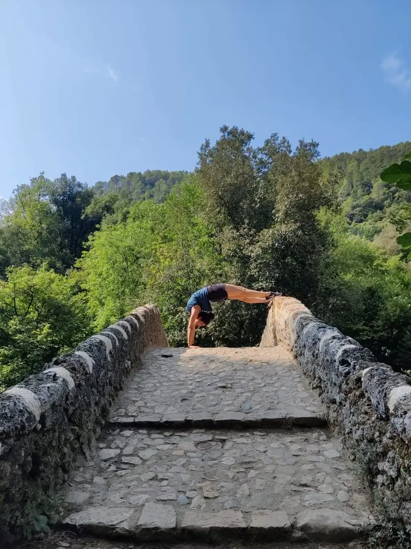 Posture du pont (Urdhva Dhanurasana) sur un pont de pierre en pleine nature